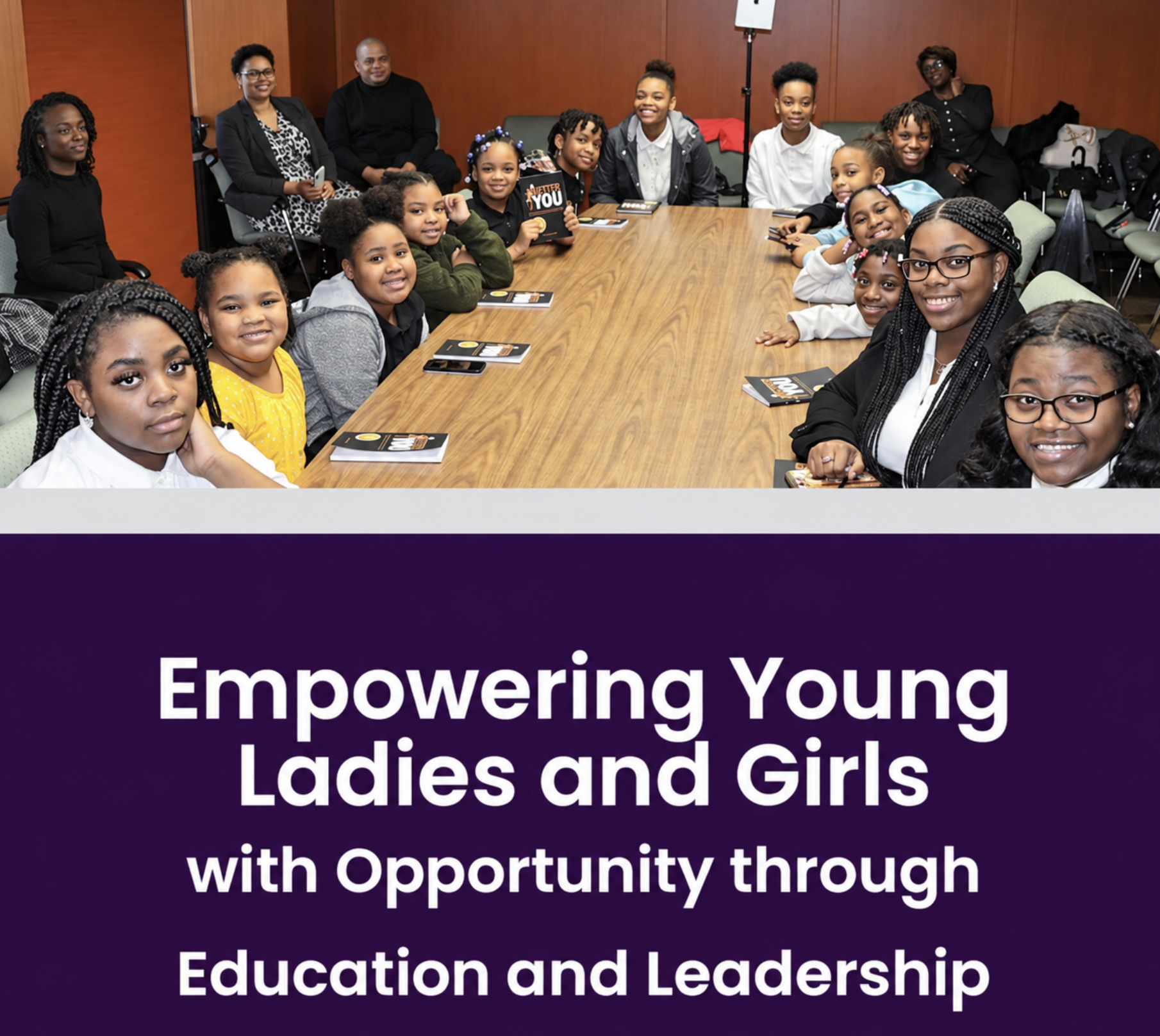 Young women and girls seated around a conference table holding Better You books