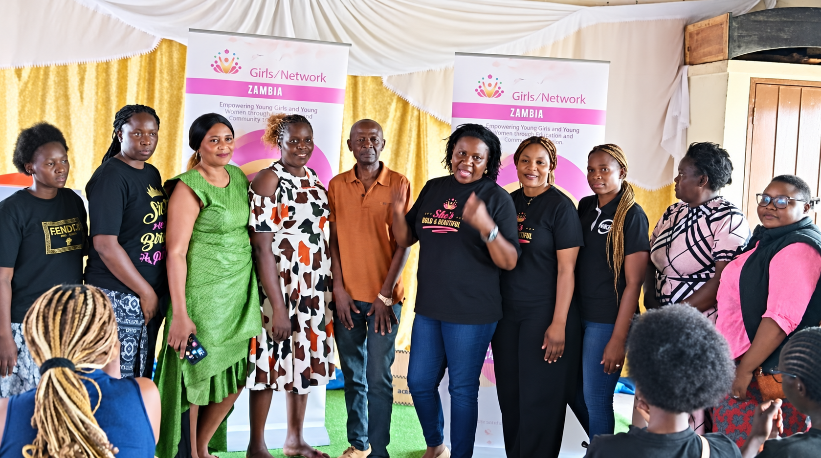 Group posing in front of Trinity Girls Network Zambia banners
