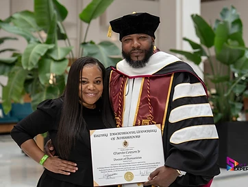 TIUAC doctoral honoree presenting his Doctor of Humanities diploma at the conferral celebration
