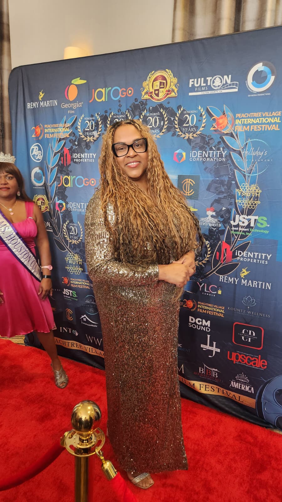 Guest in a gold sequined gown on the Peachtree Village International Film Festival red carpet