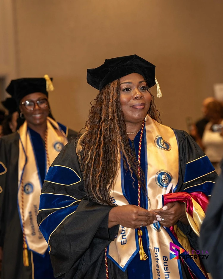 A TIUAC honoree in doctoral tam and School of Business entrepreneur stole holding her academic hood
