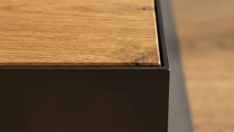 Macro detail of oak wood grain meeting a black steel edge