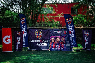 Banners de Guesumoto Sports y patrocinadores montados en el campo