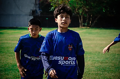 Jóvenes jugadores con camiseta del Levante UD y Guesumoto Sports caminando al campo