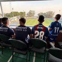 Staff y jugador observando el partido desde la grada