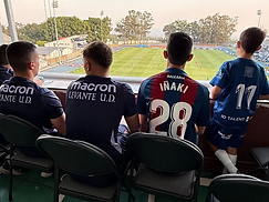 Staff y jugador observando el partido desde la grada