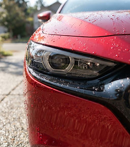 Glossy restored headlight on a red Mazda 3