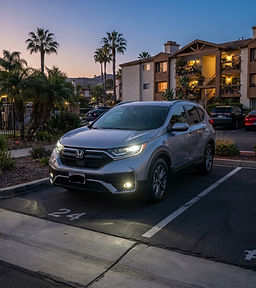 Silver Honda CR-V with bright clear headlights at dusk