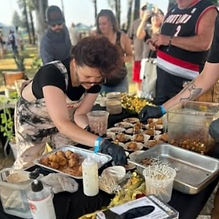 Plating food at an outdoor catering station
