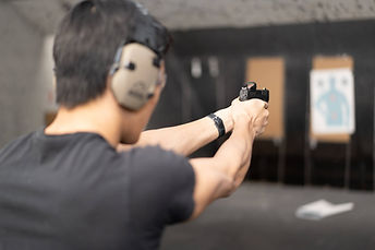 Shooter aiming a handgun at a range during a Northern Illinois shoot