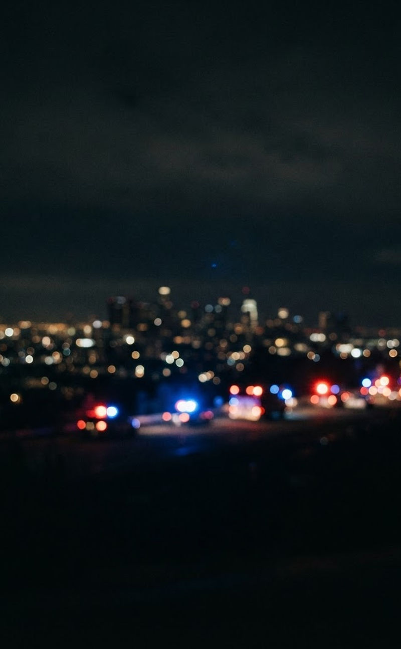 Night cityscape with soft red and blue emergency-light bokeh