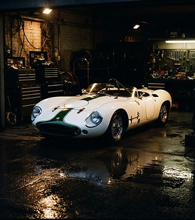 A racing car under the spotlights of a pit garage