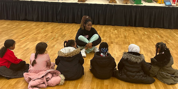 A facilitator and a group of young people in a circle during a session
