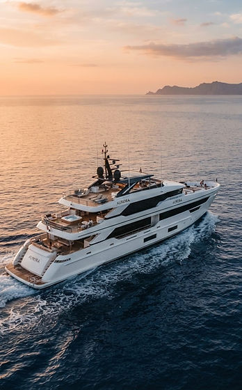 A sleek motor yacht cruising open water at golden hour