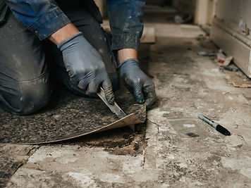 Schadstoffprüfung & Proben: Probenahme am Bodenbelag: Handschuhe lösen ein Stück Belag mit Kleber ab, Probenbeutel daneben.
