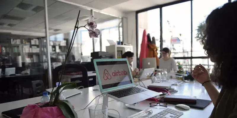 Kollegen arbeiten an Laptops in einem hellen Großraumbüro – Onectus-Analyse zu Airbnb Engineering und skalierbaren Softwareteams