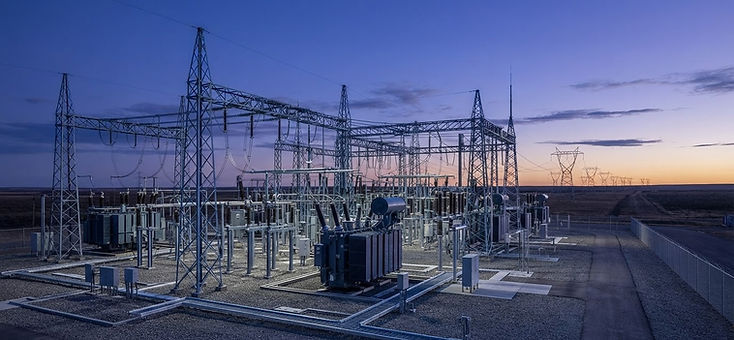 High-voltage electrical substation with lattice towers at dusk