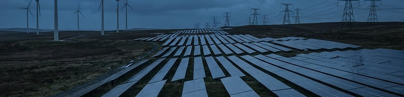 Solar panels and wind turbines with transmission towers at dusk