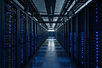 Aisle of server racks with cool indicator lighting in a data centre