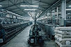 Spinning frames and yarn cones inside a textile mill