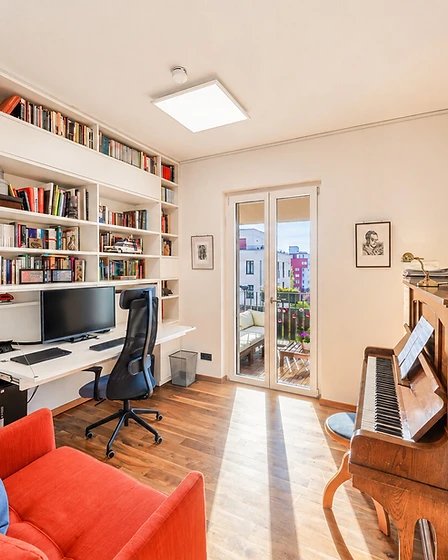 Arbeitszimmer mit deckenhohem Bücherregal und ausklappbarem Schreibtisch