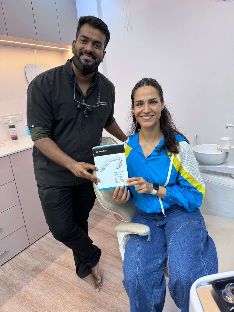 Dr. Akram with patient holding Invisalign aligners at Align And Shine Dental Clinic