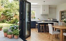 Bi-fold doors opened onto a garden from a bright kitchen