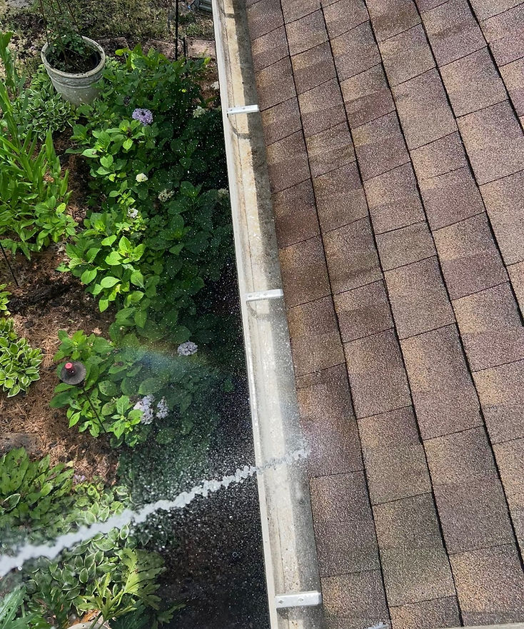 Gutter being pressure-washed with a fine water spray