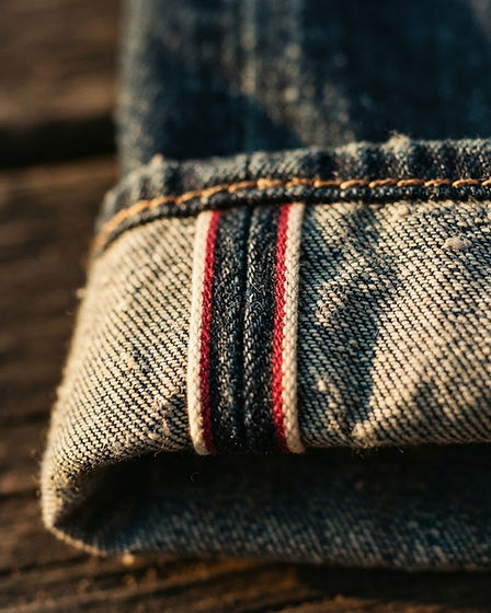 Macro detail of vintage denim selvedge with copper stitching