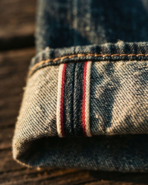 Macro detail of denim weave, selvedge and copper stitching