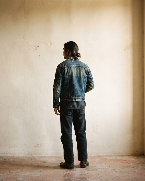 Person in a worn denim jacket in warm afternoon light