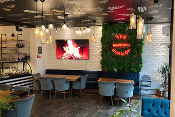 The main dining room with the neon sign glowing on the plant wall