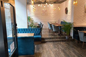 Teal velvet seating and warm pendant lights inside The Horizon