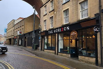 The Mansfield Horizon neon sign amid the living plant wall