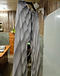 Grey and taupe diagonal band pleated trousers on a hanger