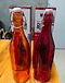 Amber and red Rotlo Giara glass bottles with their packaging boxes