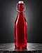 Deep red glass swing-top bottle on a dark marble pedestal
