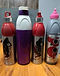 Bluplast steel, purple and pink sports water bottles lined up on a wooden table