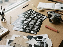 Photographic contact sheets and a film camera on a studio table