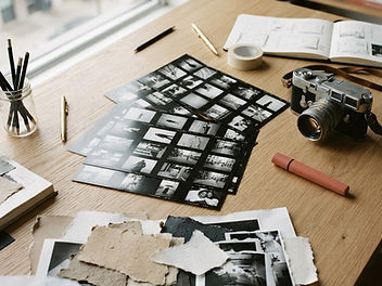 Photographic contact sheets and a film camera on a studio table