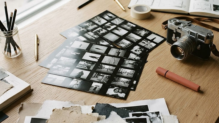 Photographic contact sheets and a film camera on a studio table