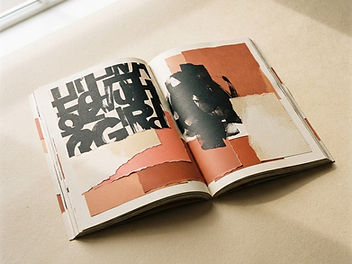 Open editorial magazine spread with expressive typography and torn paper texture