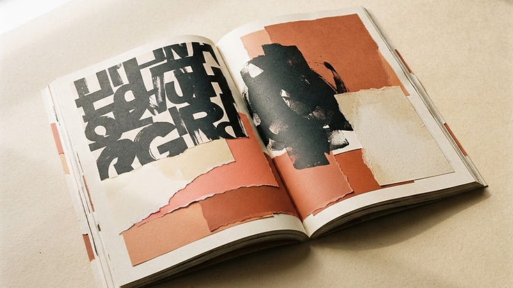 Open editorial magazine spread with expressive typography and torn paper texture