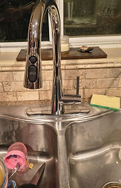 New chrome pull-down kitchen faucet installed at the same sink
