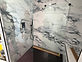 Finished marble-look shower with glass door and black hex tile floor
