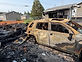 Fire-damaged vehicle and structure at a restoration site
