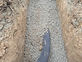 Gravel-bedded trench with drainage pipe