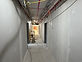 Commercial corridor with new drywall and wiring in progress