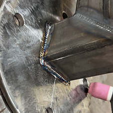 Close-up of clean, evenly stacked TIG weld beads on a steel joint