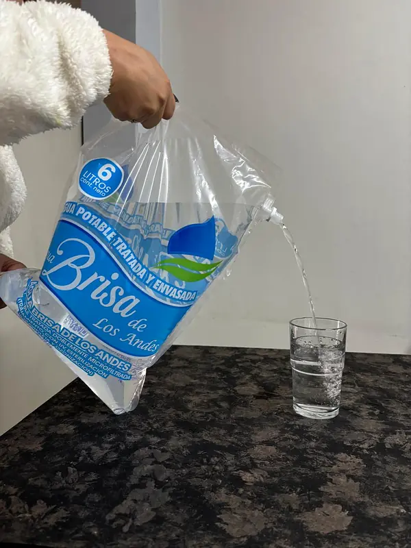 Bolsa de agua de 6 litros sirviendo un vaso por la tapa válvula